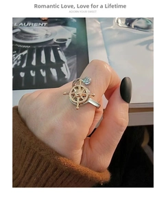 Detail of nautical rudder ring with gold accent and rose motif on a finger