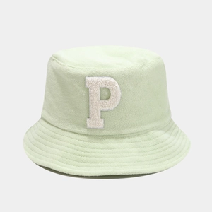 Détail du bob vert menthe avec la lettre P texturée en tissu éponge blanc brodée sur l'avant