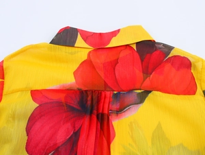 Detail of floral chiffon blouse back showing yellow fabric with red flowers and pleats