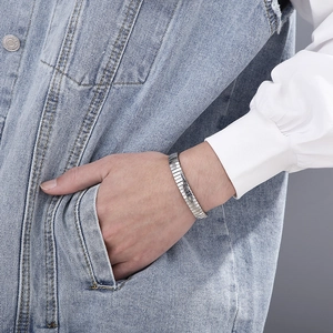 Detail of silver modular stretch bracelet in stainless steel on a model denim pocket