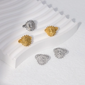 Detail of vintage embossed letter rings in gold and silver on a white wave plate
