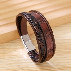 Detail of multi-layer brown braided leather bracelet with engraved anchors and magnetic clasp