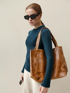Détail du grand sac cabas vintage en cuir ciré marron avec poche porté par un mannequin