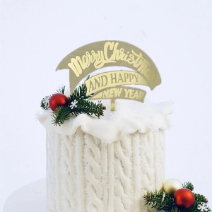 Golden Merry Christmas acrylic cake topper on a white knitted texture cake with pine branches