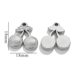 Détail d'un pendentif cerise en métal de 18mm avec surfaces texturées et lisses