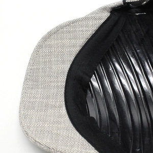 Close-up of herringbone tweed cap showing premium fabric texture and interior sweatband