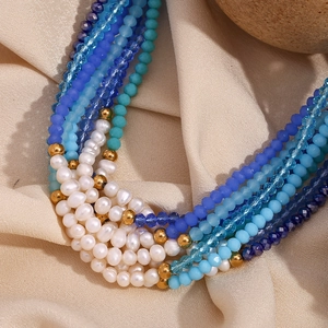 Detail view of multilayer beaded necklace with freshwater pearls and blue crystal beads