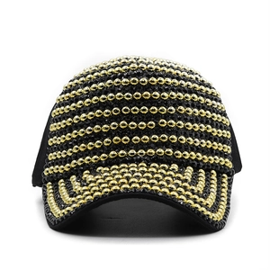 Close-up of black baseball cap with dense gold and black pearl stripe embellishments