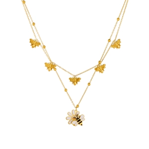 Collana doppia dorata con pendenti ape in smalto e margherita in un set fotografico