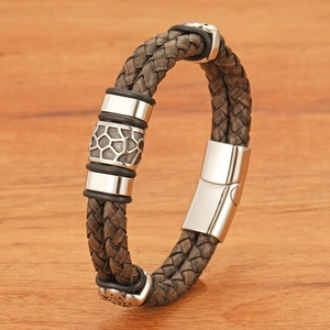 Retro double-layered braided brown leather bracelet with magnetic buckle on wood texture