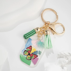 Hawaiian butterfly keychain with green tassels and acrylic pendant on white background