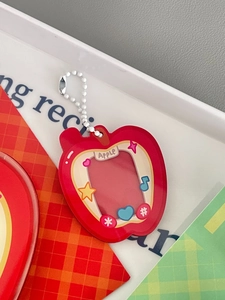 Detail of red apple acrylic photo card holder with white bead chain and cute star prints