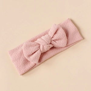 Close-up of pink textured knit fabric and bow detail on baby headband