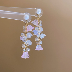 Detail of lily of the valley tassel earrings with pearls and purple resin flowers