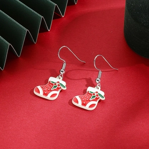 Detail of Christmas stocking drop earrings in red and green enamel with holiday motifs