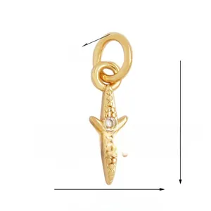 Macro view of gold plated star charm with green gemstone and micro-pave crystals