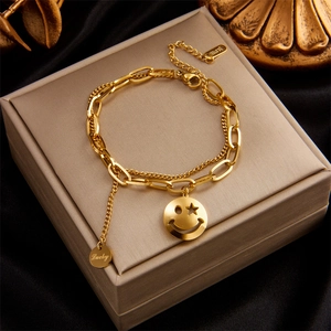 Double-layered gold stainless steel bracelet with smiley face charm on gift box