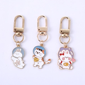 Detail view of cartoon rabbit and cat enamel keychains made of polished zinc alloy metal
