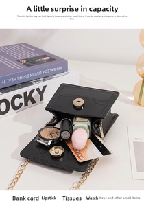 Detail showing the inner storage of a black glossy mini jelly bag with gold chain strap