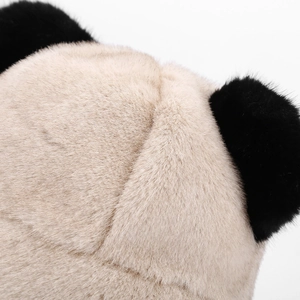 Close-up detail of soft fluffy faux fur material in cream and black for plush hats