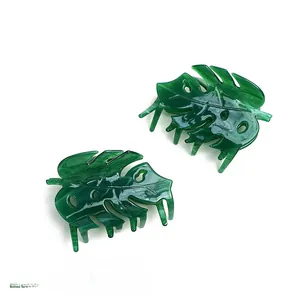 Detail view of emerald green acetate monstera leaf hair claw with cutout patterns