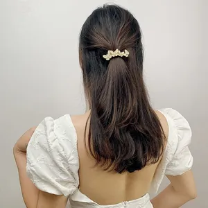Detail of a sparkling rhinestone butterfly hair clip worn on a woman's wavy hair