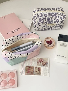 Detail of leopard print and polka dot pouches with white zippers for daily storage