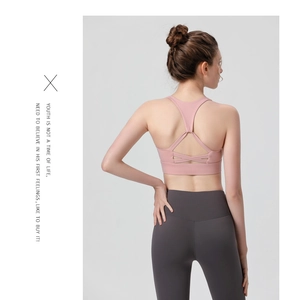 Vue détaillée du dos d'une brassière rose croisée et d'un legging de sport gris foncé
