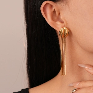 Detail of elegant gold-plated geometric fringe earrings shown on a model's ear