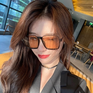 Retro oversized square sunglasses with orange tinted lenses and black frames for women