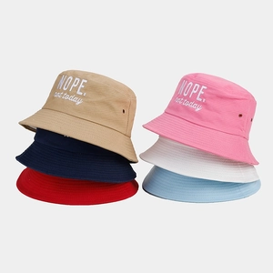 Close-up of cotton bucket hats featuring NOPE letter embroidery and metal eyelets detail