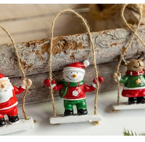 Detailed view of hand-painted resin snowman on a wooden swing with natural jute rope