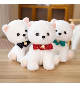Detailed view of three white fluffy puppy plushies with colorful bow ties and bells
