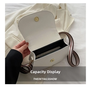 Detail shot showing the spacious interior of a white saddle bag holding a smartphone