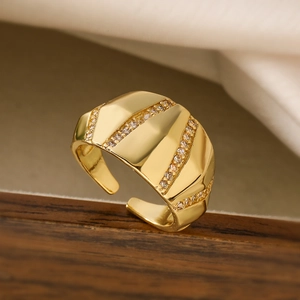 Gold plated geometric open ring with three rows of sparkling zircons on dark wood