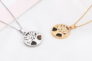 Detail of Tree of Life pendants in gold and silver finishes on polished steel chains