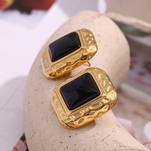Macro view of vintage hammered gold square earrings with black acrylic inlay details