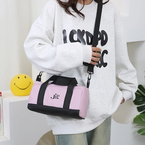 Pink and black nylon cylinder crossbody bag with JLP logo and adjustable strap