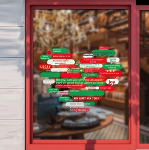 Detailed Christmas window stickers with red and green text bubbles on glass pane