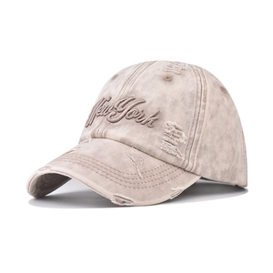 Close-up of New York 3D embroidery on washed khaki baseball cap with distressed details