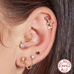Close-up of 925 sterling silver ear piercing set with gold and silver chain earrings