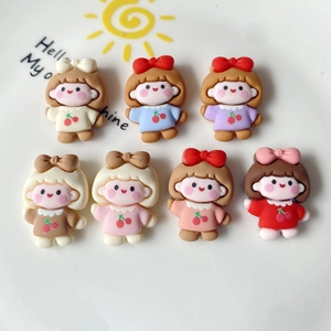 Flat lay of colorful resin cartoon girl charms with cherry details for DIY crafts