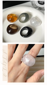 Detail view of retro resin rings in multiple colors with frosted white ring on finger