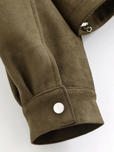 Macro de manchette de veste en daim olive avec bouton métallique et surpiqûres précises