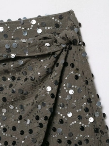 Dettaglio del tessuto grigio scuro con paillettes argento e lavorazione artigianale