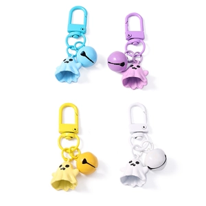 Cartoon ghost keychains with bells in blue purple yellow and white on white background