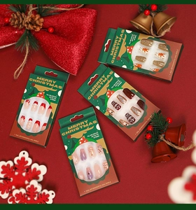 Close-up of Christmas themed soft gel ballerina press-on nails in festive gift boxes