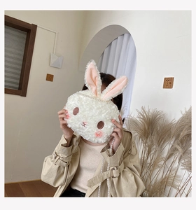 Detail of white plush bunny crossbody bag with elegant pearl chain and cute rabbit face