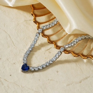 Elegant heart blue sapphire necklace with zircon inlay on a satin decorative surface