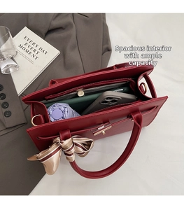 Vue macro d'un grand sac à main bordeaux avec compartiment zippé et grande capacité interne